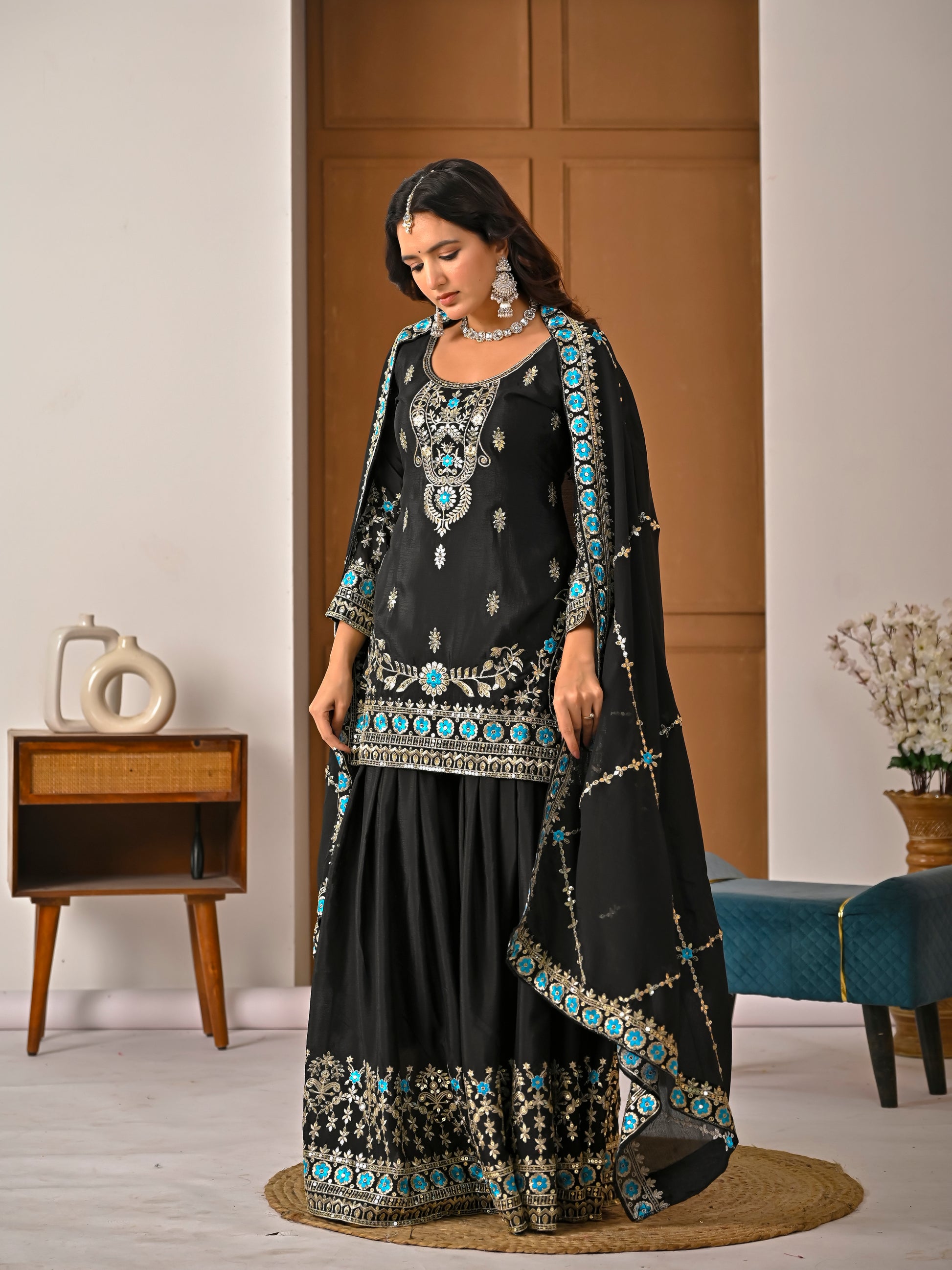 Side view of black kurta sharara set highlighting embroidery and elegant flare