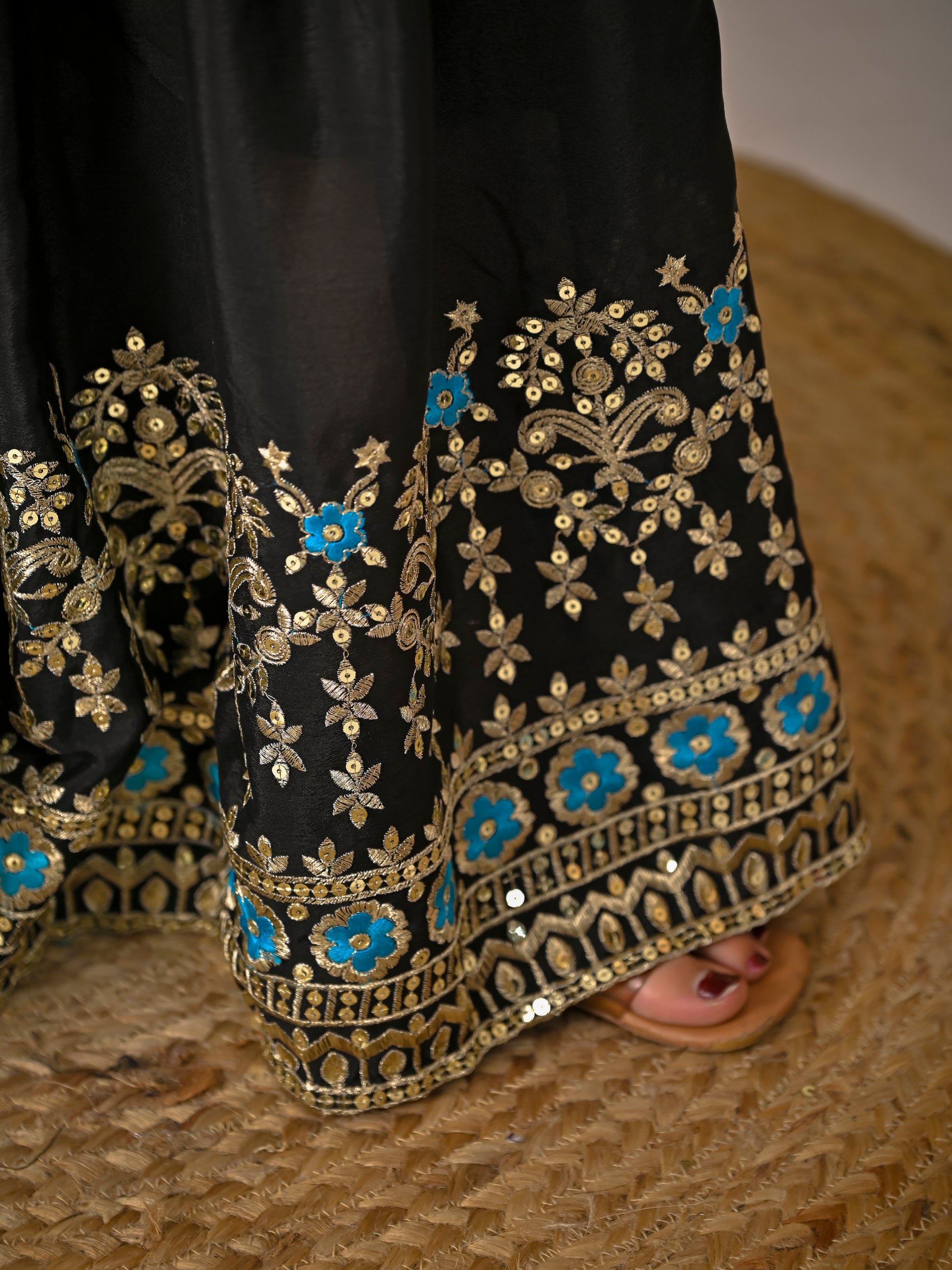 Close up of black sharara palazzo hem featuring intricate embroidery and premium finish