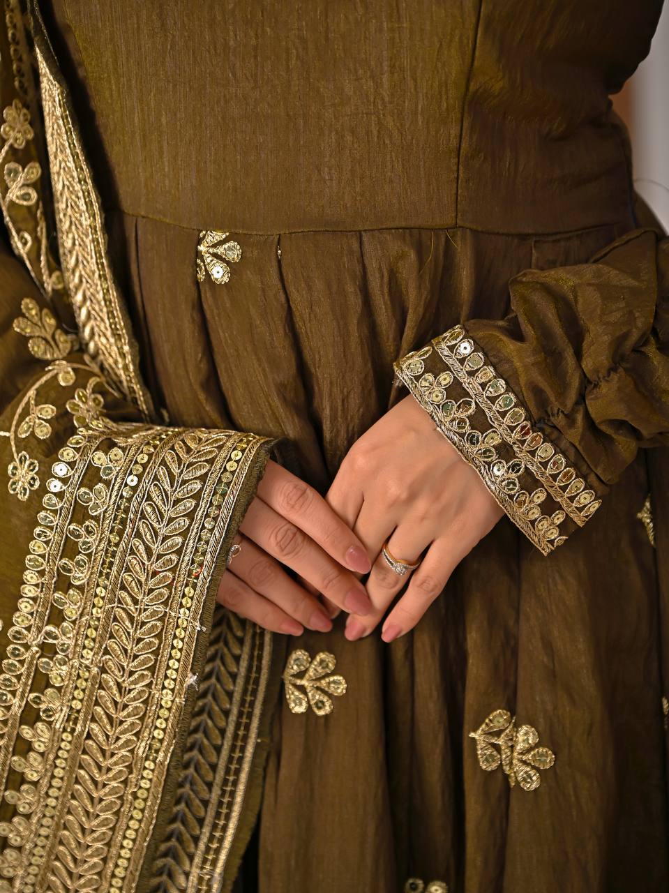 Close-up embroidery work on olive green Anarkali suit with intricate floral motifs