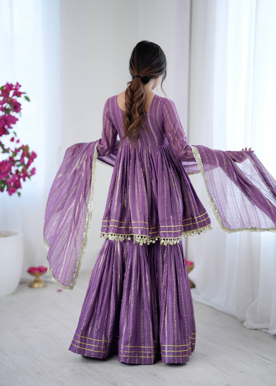 Side pose of purple sharara suit with golden stripes and dupatta, stylish Indian ethnic wear for women