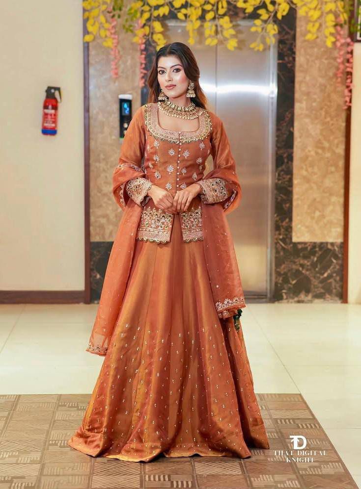 rust color embroidered lehnga with heavy neck work, full sleeves and matching dupatta for wedding and festive wear